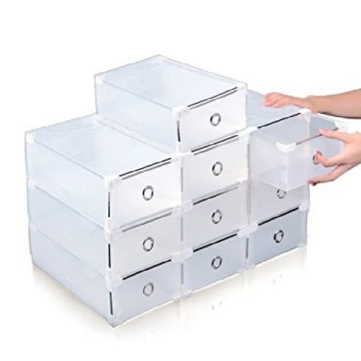 A person is organizing a stack of STURDY METAL EDGE STACKABLE TRANSPARENT PLASTIC SHOEBOX STORAGE DRAWERS, arranged in a stair-step design. Nine drawers feature circular handles, and one drawer is being pulled out slightly.